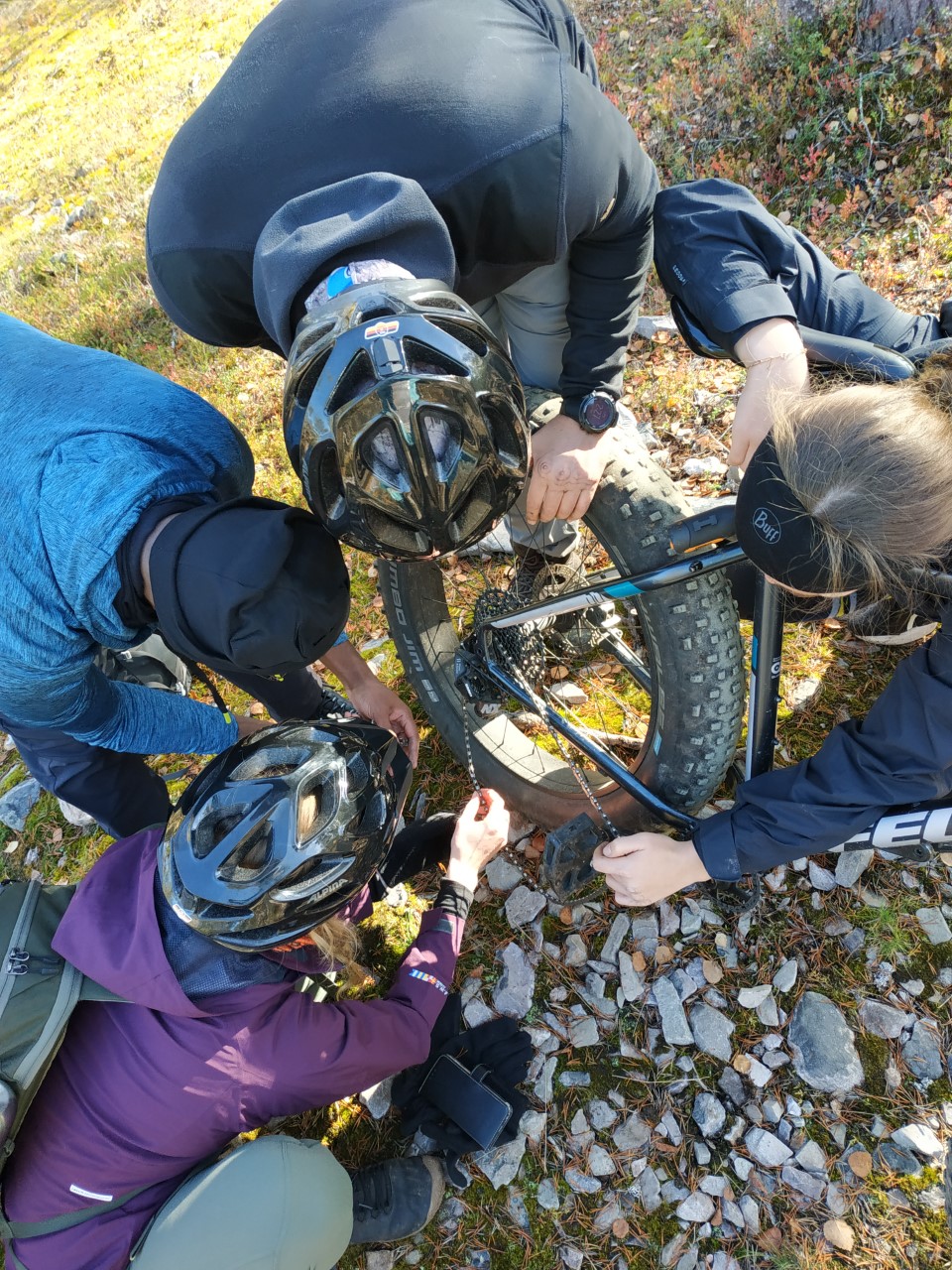 A group of students working together fixing a bicycle tire