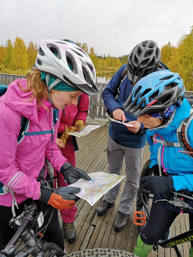 Three cyclists are looking at a map.