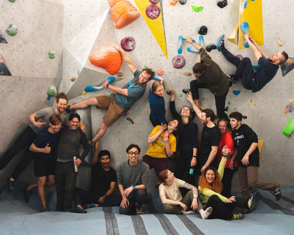 A group of students laughing and bouldering.
